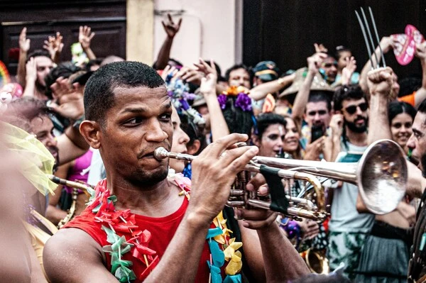 Comunidade local participando de evento cultural com pessoas interagindo, fotografando e compartilhando experiências em praça pública
