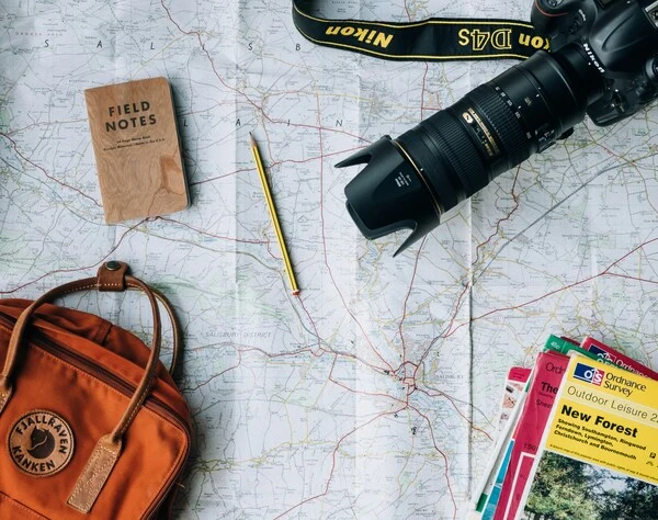 Smartphone mostrando aplicação de roteiros turísticos com mapa interativo, trajetos personalizados e pins de atrações em uma cidade
